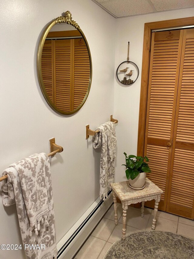 bathroom featuring tile patterned flooring, a paneled ceiling, and a baseboard heating unit