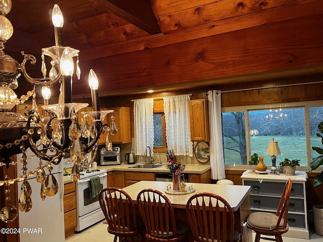 kitchen with white range with electric cooktop, wood walls, sink, and hanging light fixtures