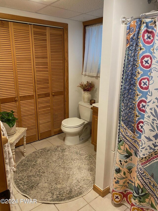 bathroom featuring toilet, vanity, a paneled ceiling, and tile patterned floors