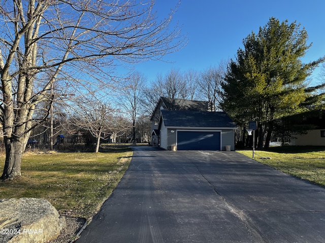 view of side of property featuring a garage and a lawn