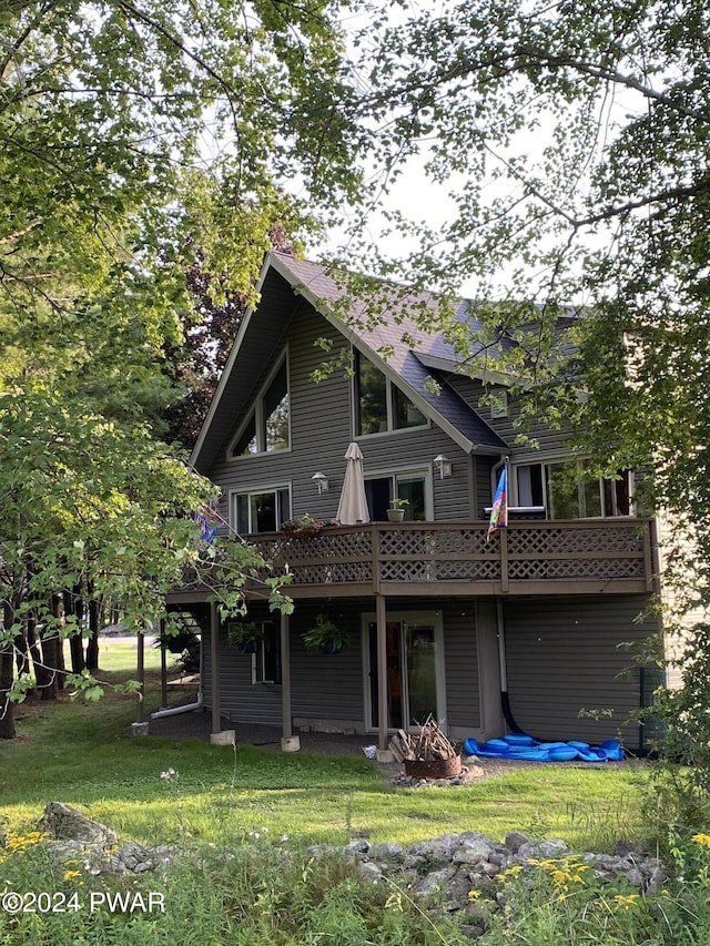 back of house with a wooden deck and a yard