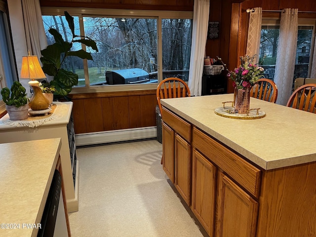 kitchen with a center island, a baseboard radiator, and wooden walls