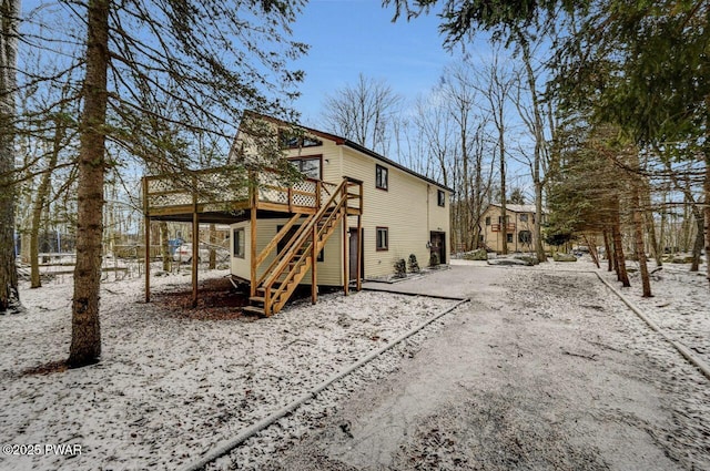 snow covered rear of property with a deck