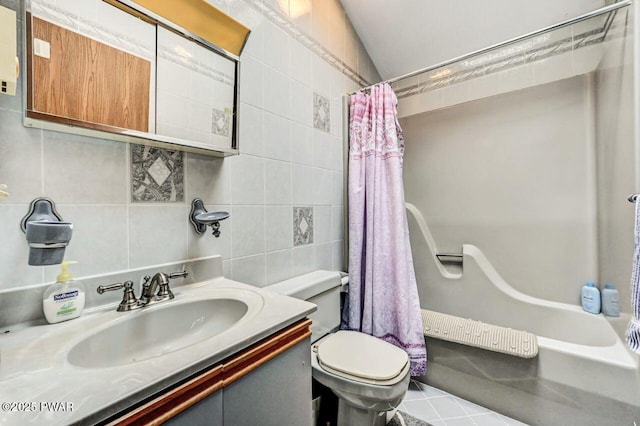 full bathroom featuring vanity, vaulted ceiling, shower / bath combo with shower curtain, tile walls, and toilet