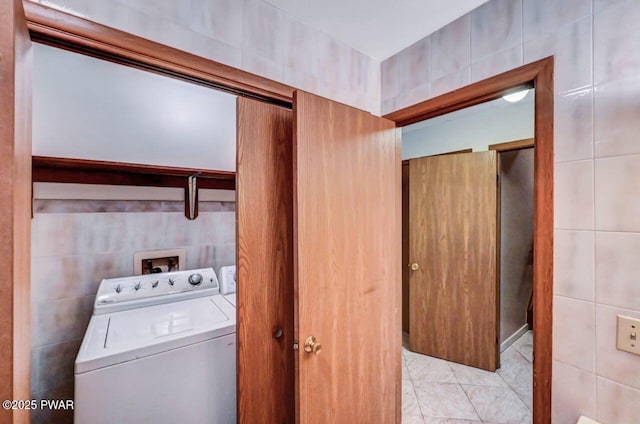 laundry area with washer and dryer and tile walls