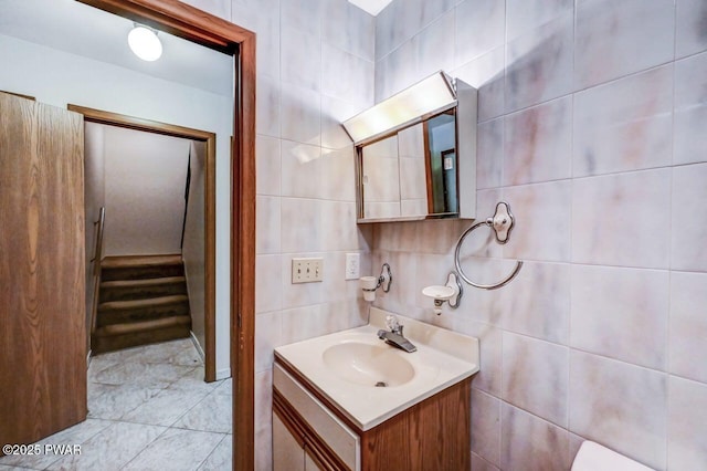 bathroom featuring vanity, decorative backsplash, and tile walls