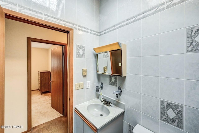 bathroom featuring vanity and tile walls