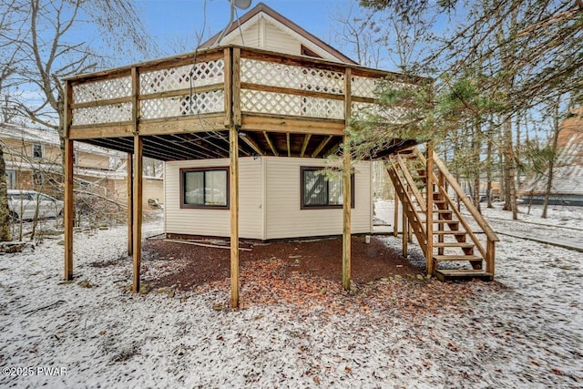 snow covered back of property featuring a wooden deck