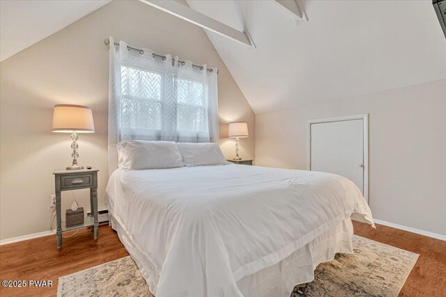 bedroom with lofted ceiling, wood finished floors, and baseboards