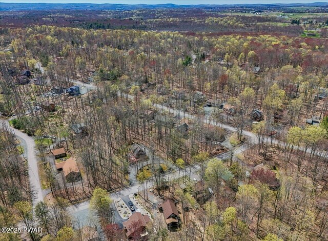 birds eye view of property featuring a forest view