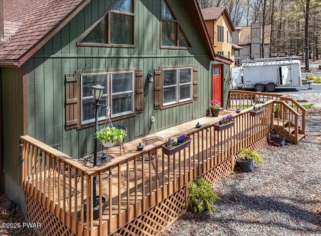 rear view of house with roof with shingles and a deck