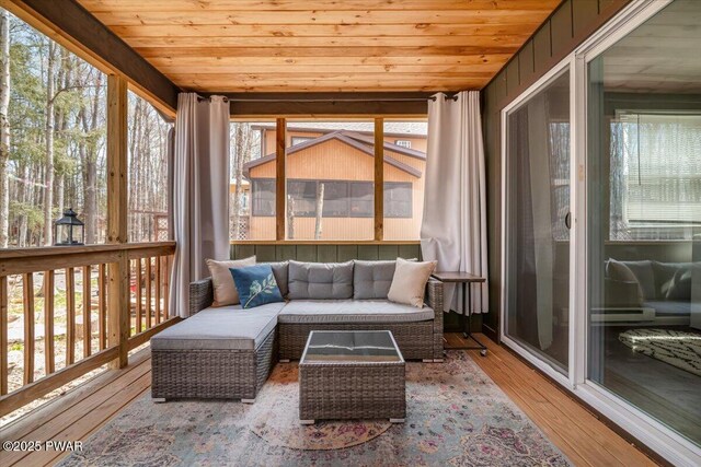 sunroom / solarium featuring wood finished floors, a wealth of natural light, and wood ceiling