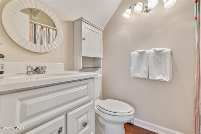 full bathroom with toilet, baseboards, lofted ceiling, wood finished floors, and vanity