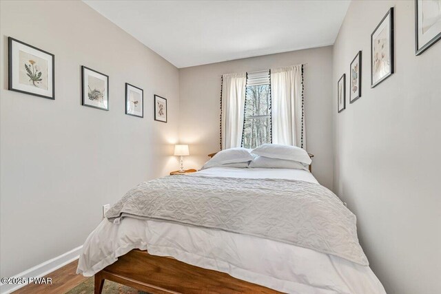 bedroom with baseboards and wood finished floors
