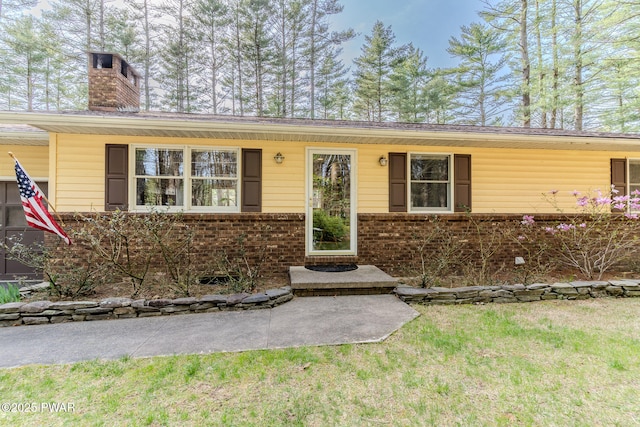 117 Circle Dr, Hawley, PA 18428 - view of front of home with brick siding, a chimney, and a front yard