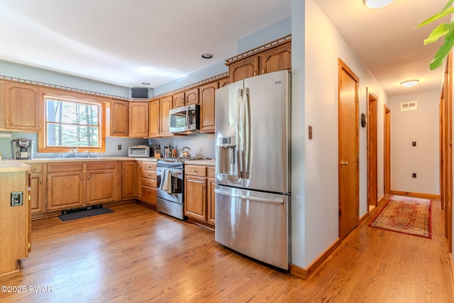 117 Circle Dr, Hawley, PA 18428 - kitchen with visible vents, light countertops, a sink, light wood finished floors, and appliances with stainless steel finishes
