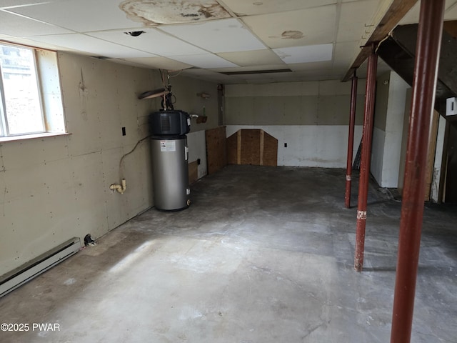 below grade area with water heater, baseboard heating, and a paneled ceiling
