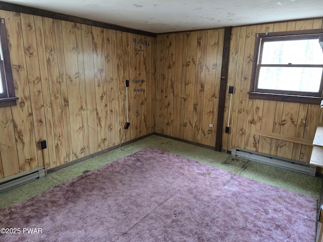unfurnished room featuring carpet floors, wood walls, and baseboard heating