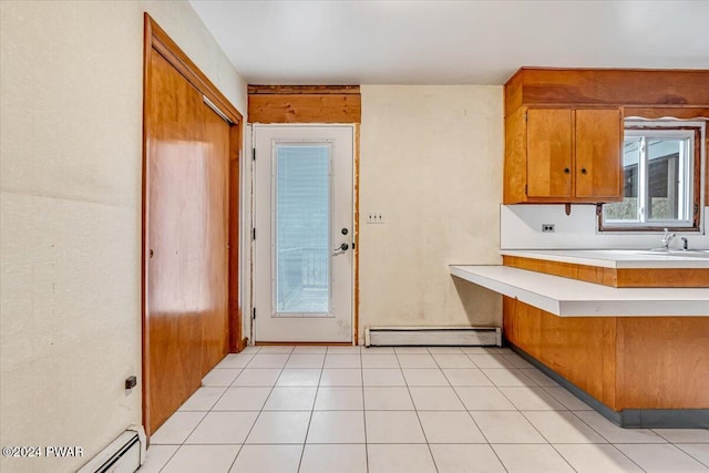 kitchen with sink, light tile patterned floors, and baseboard heating