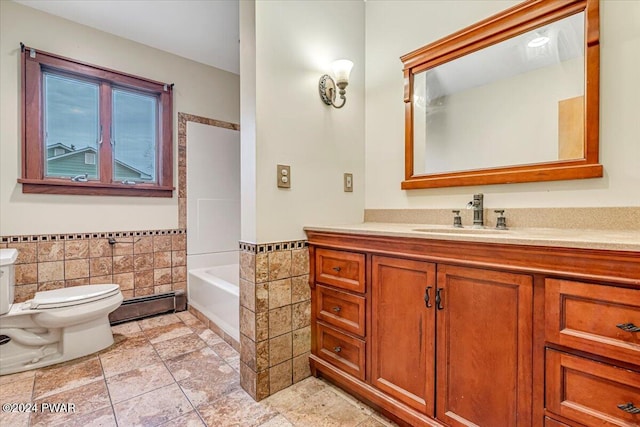 bathroom featuring vanity, toilet, baseboard heating, and tile walls