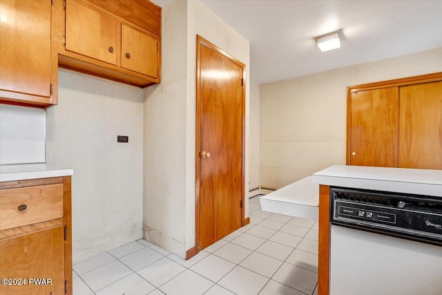 kitchen featuring light tile patterned floors, white dishwasher, and baseboard heating