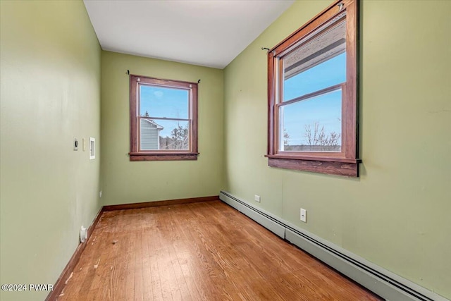 spare room with light wood-type flooring and a baseboard radiator