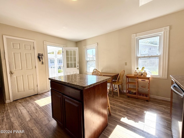 kitchen with dishwasher, a center island, dark brown cabinets, and dark hardwood / wood-style floors