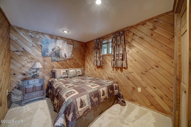 bedroom featuring light carpet and wooden walls