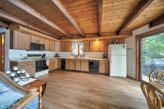 kitchen featuring beam ceiling, a healthy amount of sunlight, light hardwood / wood-style flooring, and black appliances