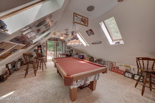 game room featuring a wealth of natural light, vaulted ceiling with skylight, ceiling fan, and pool table