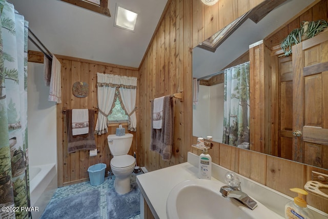 full bathroom featuring shower / tub combo, vaulted ceiling with skylight, vanity, toilet, and wood walls