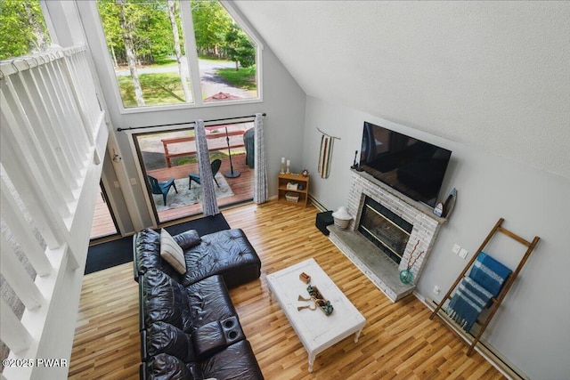 173 Paper Birch S, Tafton, PA 18464 - living room featuring wood finished floors, a glass covered fireplace, lofted ceiling, and a textured ceiling