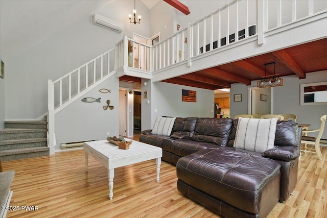 173 Paper Birch S, Tafton, PA 18464 - living area featuring a baseboard heating unit, a wall unit AC, wood finished floors, stairway, and a chandelier