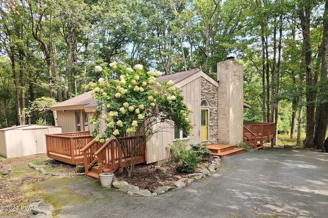 exterior space with a storage shed and a wooden deck