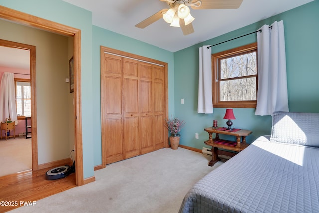 bedroom featuring baseboards, carpet floors, a closet, and a ceiling fan