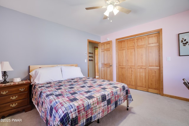 bedroom with a closet, light colored carpet, a ceiling fan, and baseboards