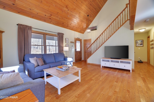 living area with stairway, light wood-style flooring, wood ceiling, and high vaulted ceiling