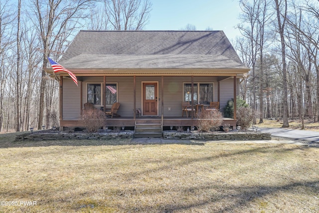 view of front facade with a porch, a front lawn, and roof with shingles