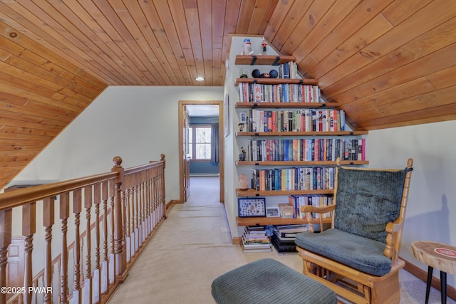 sitting room with wooden ceiling, carpet, baseboards, and vaulted ceiling