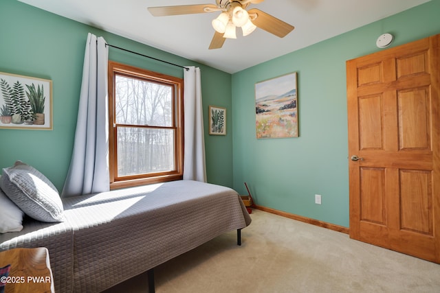 bedroom featuring baseboards, light carpet, and a ceiling fan