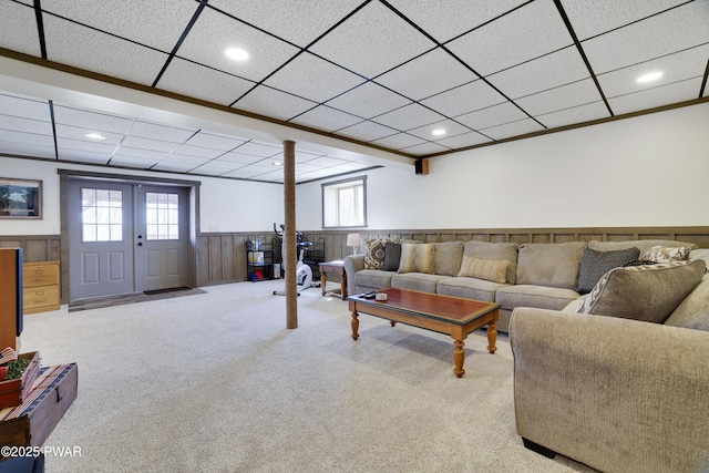 living room with a wainscoted wall, recessed lighting, a paneled ceiling, and carpet floors