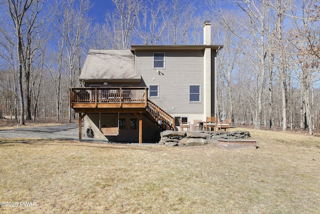 back of property with a deck, stairway, a lawn, and a chimney