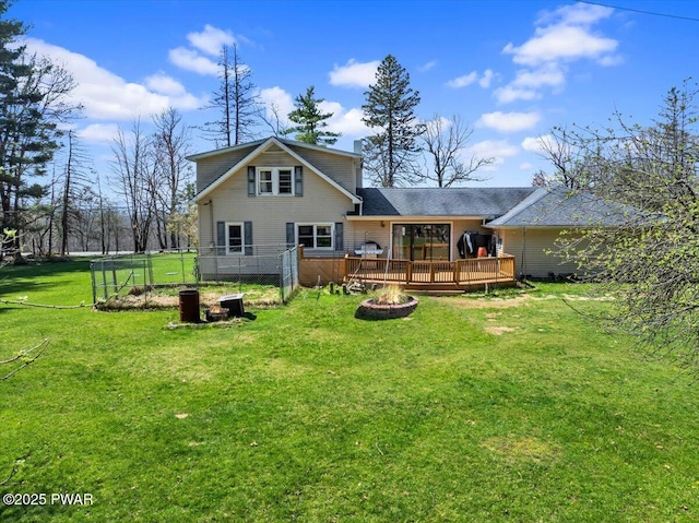 back of house featuring a wooden deck, a yard, and an outdoor fire pit