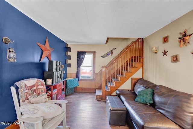 living room featuring crown molding, stairs, wood finished floors, and a wainscoted wall
