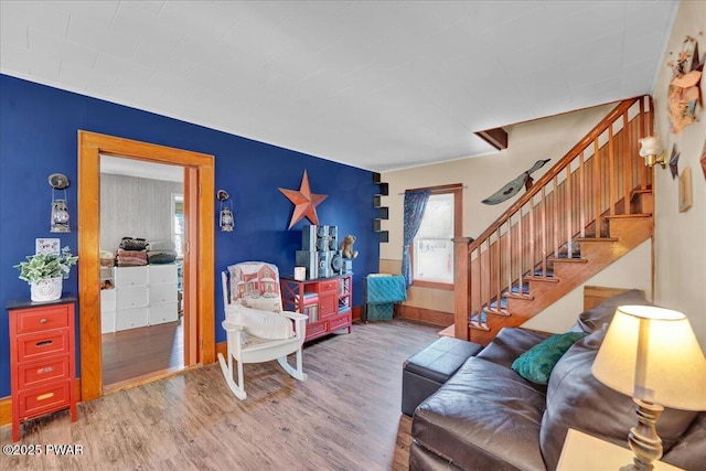 living area featuring wood finished floors and stairway