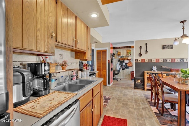 kitchen with a sink, a wood stove, light countertops, tasteful backsplash, and dishwashing machine