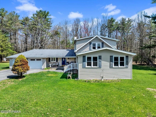 view of front facade with a garage, a front yard, a chimney, covered porch, and driveway