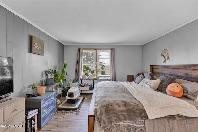 bedroom with crown molding and wood finished floors