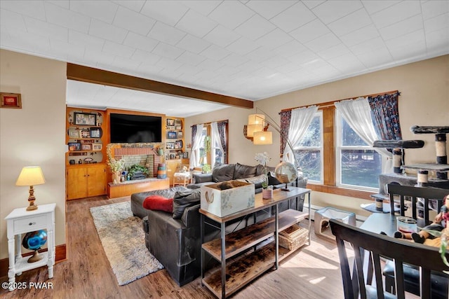 living room featuring beamed ceiling and wood finished floors