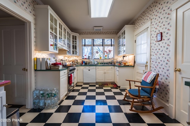 kitchen featuring dishwasher, sink, white cabinets, high end range, and ornamental molding